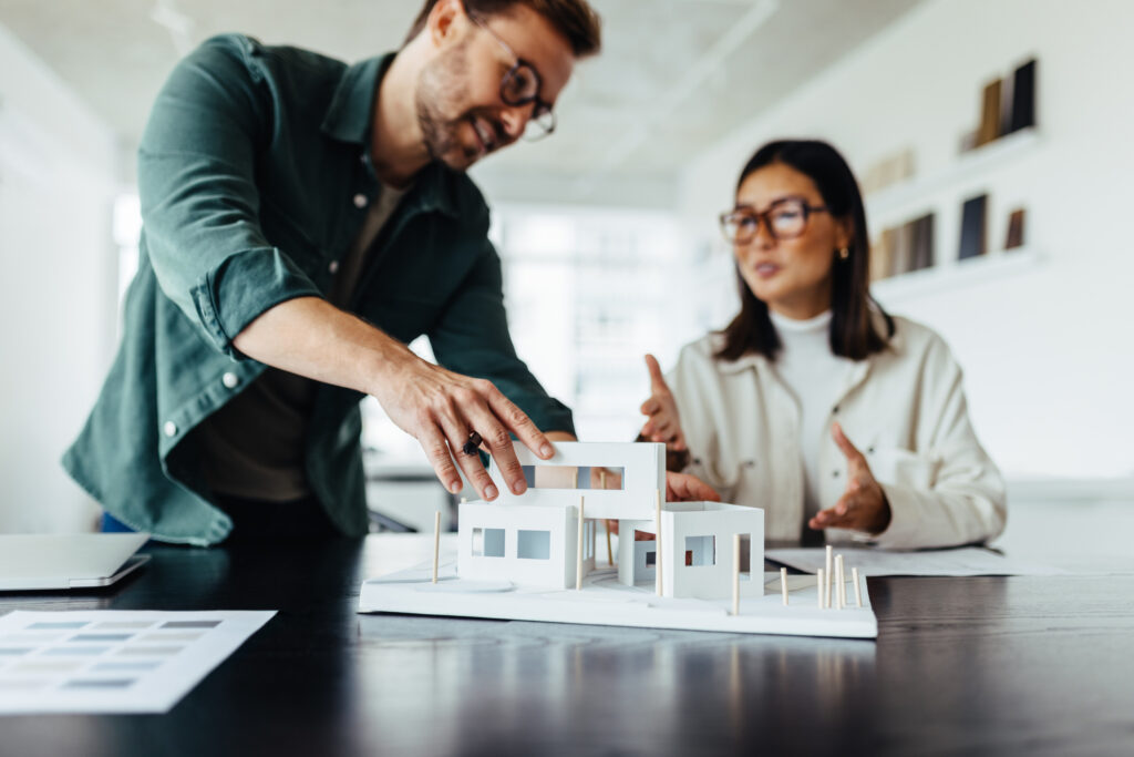 architects working on a house model in an office