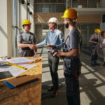 happy project manager greeting a construction worker in the building.