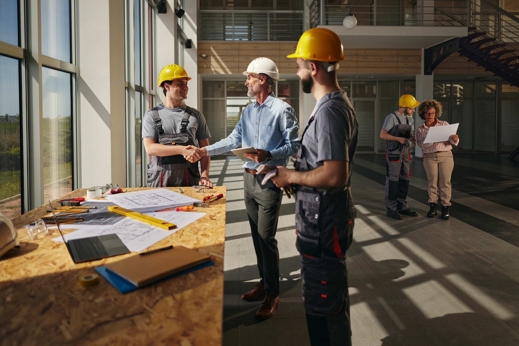 happy project manager greeting a construction worker in the building.