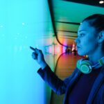 young woman using interactive touchscreen in futuristic tunnel