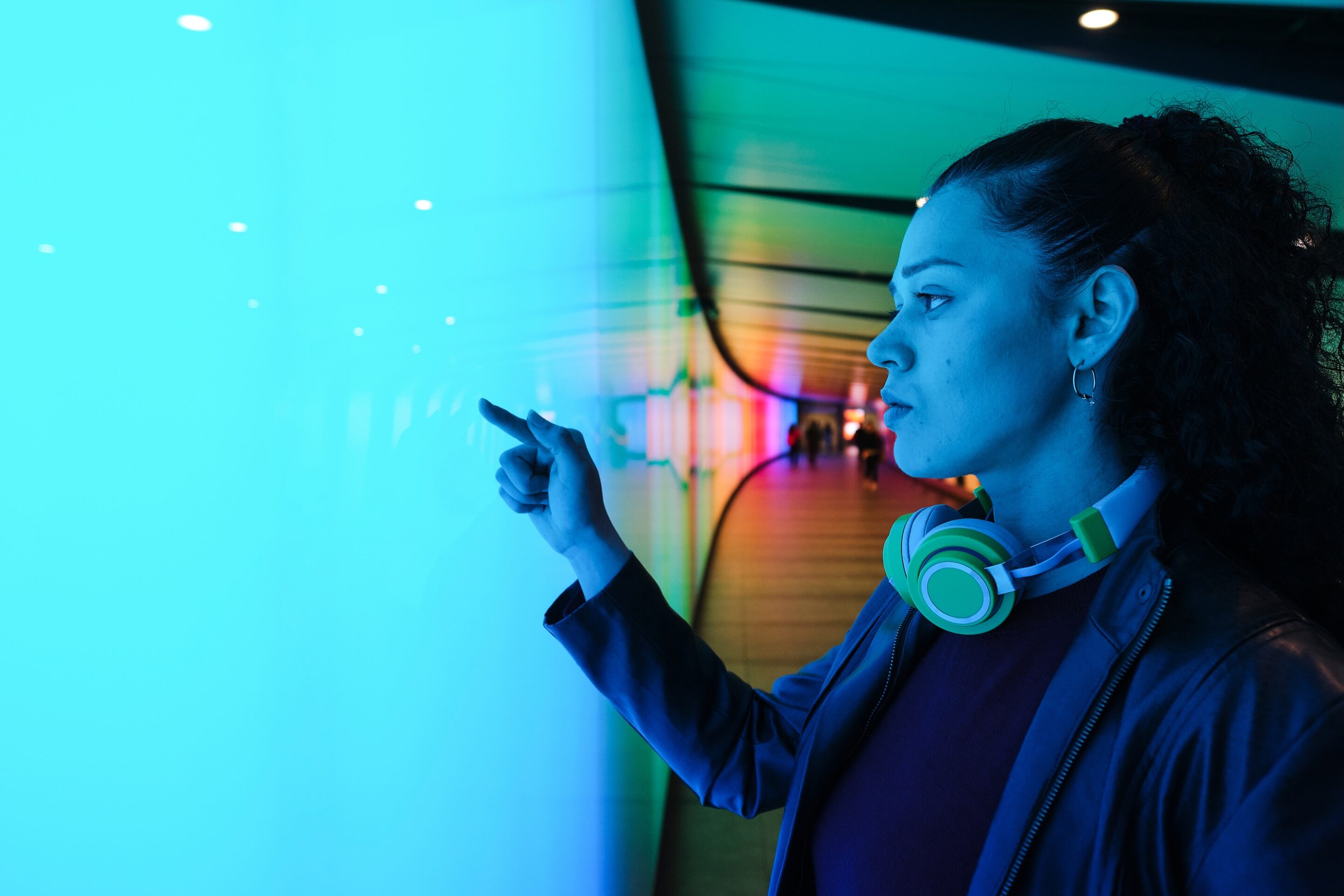 young woman using interactive touchscreen in futuristic tunnel