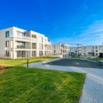 modern residential complex with green areas and construction crane on sunny day