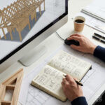 Architekt prüft ein Modell am Bildschirm und macht parallel Notizen in ein Notizbuch. Fokus auf Detailarbeit und Genauigkeit. Dieses Bild wurde mithilfe von KI generiert